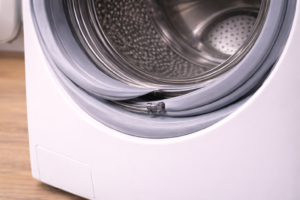 Newly installed washing machine door seal showing slight misalignment around drum opening